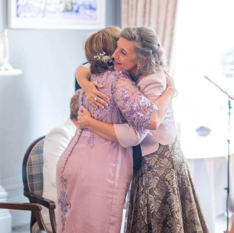 sharing a hug after reading a bespoke poem created for 2 brides